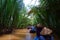 My Tho, Vietnam: Tourist at Mekong River Delta jungle cruise with unidentified craftman and fisherman rowing boats on flooding mud