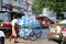 Myanmese worker man pushing the three wheel of water tanker barrow on the street at Yangon