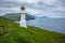 Mykines lighthouse and cliffs on Faroe islands. Hiking landmark. Denmark