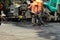 MYKOLAIV, UKRAINE - AUGUST 04, 2021: Workers with road repair machinery laying asphalt