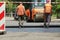 MYKOLAIV, UKRAINE - AUGUST 04, 2021: Workers with road repair machinery laying new asphalt