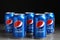 MYKOLAIV, UKRAINE - FEBRUARY 9, 2021: Many cans of Pepsi on table against black background