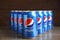 MYKOLAIV, UKRAINE - FEBRUARY 9, 2021: Many cans of Pepsi on wooden table