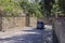 Mykolayiv, Ukraine - August 17, 2020: Ford Transit minibus drives along an empty city street with stone walls on the sides