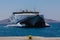 Mykonos, Greece - August 2, 2021: A big large catamaran ferry arrives in the harbor of Mykonos. One of the islands in the cyclades