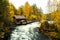 Myllykoski wooden watermill by the river rapids during colorful autumn foliage in Oulanka National Park, Northern Finland.