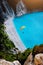 Myrtos Beach, Kefalonia Island, Greece. Figure of a parachutist skydiver with orange parachute against a blue lagoon bay