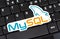 MySQL logo sticker laying on a laptop keyboard, object closeup, nobody. My SQL database technology symbol, website backend