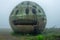 Mysterious Abandoned Spherical Structure with Moss in Foggy Landscape Enigmatic and Dilapidated Architecture in Nature