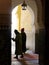 Mysterious cloaked figures in palace archway, Meknes, Morocco