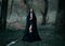 Mysterious fantasy gothic woman dark witch obsessed by evil. Girl demon vampire in black dress cape hood. walk in dark