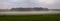 Mysterious farmland landscape with mist hanging over agriculture field