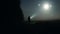 A mysterious figure with torch looking at glowing UFO lights in the sky.. On a spooky misty night in the countryside