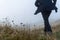 A mysterious figure wearing a coat running in the background, out of focus, in a field on a misty winters day