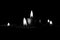 Mysterious grayscale  shot of candles lighting up creating a romantic atmosphere