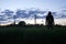 A mysterious hooded man looking at the sunset in a field of Buttercups. On a spring evening