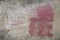 Mysterious and intriguing red paint stain on weathered wall, abstract textured background