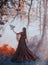Mysterious lady in gorgeous burgundy red luxurious dress and curly dark hair stands in thick foggy forest, queen of