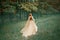 Mysterious lady in long light expensive luxury dress with long trailing train runs along forest path, new Cinderella