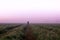 A mysterious lone figure standing in a field on a beautiful early misty morning