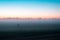 A mysterious lone ghostly, figure standing in a field just before sunrise. On a misty summers morning.