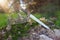 mysterious and magical photo of silver king crown and sword over the stone in the England woods or field landscape with light