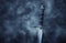 mysterious and magical photo of silver sword over gothic black background with smoke. Medieval period concept.