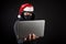 Mysterious male santa hacker holding laptop computer