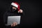 Mysterious male santa hacker holding laptop computer