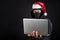 Mysterious male santa hacker holding laptop computer