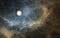 Mysterious midnight cloudy sky with full moon and moonlit clouds