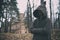Mysterious monk or wizard in hooded robe stands in forest against the background of medieval castle or monastery
