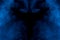 Mysterious pattern between two clouds of cigarette blue vapor on a dark background