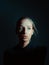 Mysterious portrait of girl with shadow pattern on her face in dark black studio