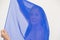 Mysterious serious lady behind blue cloth