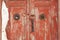 Mysterious snowy old wooden red door. Mysterious entrance to the house.