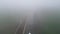 Mysterious voyage: aerial view of cargo canal ship passing through foggy winter canal