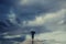 Mysterious woman with umbrella crosses a bridge to the surreal view of the sky