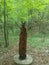 A mysterious wooden statue stands as a sentinel in the heart of the forest