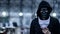 Mystery hoodie man with broken black mask holding white mask in his hand. Anonymous social masking or bipolar disorder concept