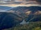 Mystery landscape with sunset sky and mountains hills, dark forest foreground with lake Sinevir