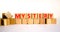 Mystery symbol. The concept word Mystery on wooden cubes. Beautiful white table, white background, copy space. Business and