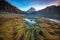 Mystic landscape with colored autumn grass and wooden bridge at