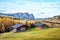 Mystic  magical fantastic autumn landscape with wooden houses in the backgroundin Alpe di Siusi in the Dolomites Alps. Exotic