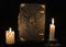 Mystic still life with black magic book and two burning candles