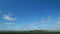 Mystic white clouds flying over green autumn field. Clouds fly across the blue sky. Timelapse.