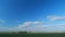 Mystic white clouds flying over green autumn field. Clouds fly across the blue sky. Timelapse.