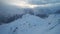 Mystical dawn with clouds in snowy mountains