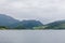 A mystical fjord in Norway with mountains and fog hanging over the water in a beautiful monochrome blue color