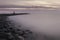 Mystical foggy sea and rocky shore in the evening